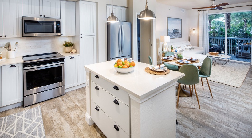 stylish apartment kitchen with kitchen island and private patio at 1333 South Ocean apartments in Pompano Beach