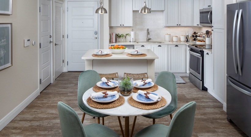 modern dining room with designer cabinetry and a kitchen island at 1333 South Ocean apartments in Pompano Beach